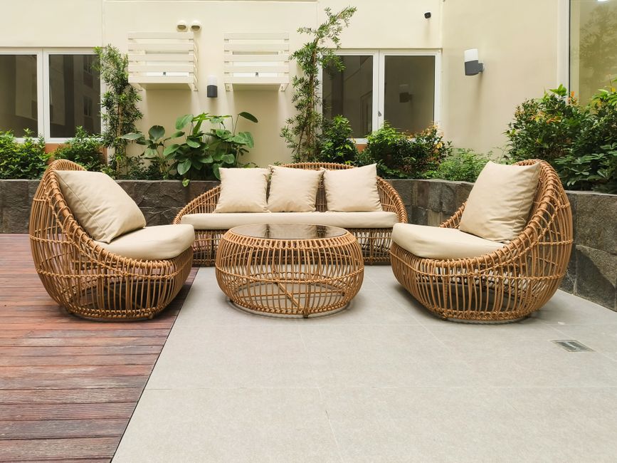 Rotan loungestoel op houten terras buiten Rotan loungestoel op houten terras buiten